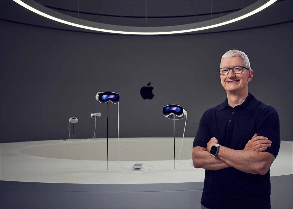 Apple CEO Tim Cook 站在Apple Vision Pro 装置的显示器旁。